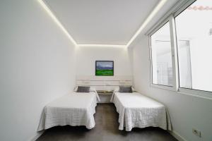 two beds in a white room with a window at Villa Carlota Costa Adeje in Adeje +10 photos