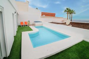 a swimming pool on the side of a house at Villa Carlota Costa Adeje in Adeje