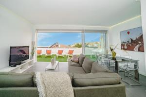 a living room with a couch and a table and a television at Villa Carlota Costa Adeje in Adeje