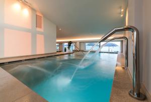 a swimming pool in a building with an indoor swimming pooliterator at Hesperia Hotel & Residence in Lido di Jesolo