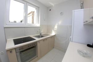 cocina blanca con fregadero y ventana en Lila Apartments, en Zadar