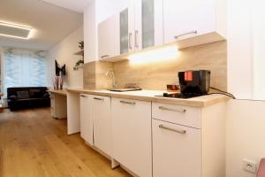 uma cozinha com armários brancos e um lavatório em Central STUDIO WORK and TRAVEL em Viena