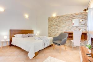 1 dormitorio con cama y pared de ladrillo en Holiday Home Batel, en Pula