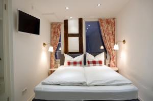 a bedroom with a white bed with red and white pillows at Apartment Zentral im Herzen der Altstadt in Tübingen