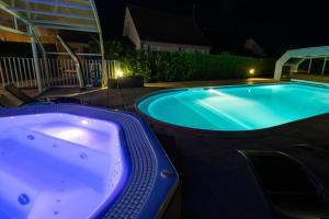 a jacuzzi tub in a backyard at night at Logis Hotel Restaurant L'Escapade in Le Pêchereau
