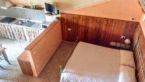 um pequeno quarto com uma cama e uma cozinha em Agriturismo Renzano garden apartments em Salò