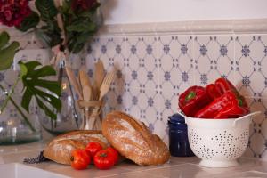 una encimera con pan y tomates y un tazón de pan en Ca la Casilda, en Prades