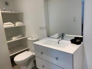 Un baño blanco con inodoro y lavabo. en Chalet TOUSVENTS, en Saint-Georges-de-Didonne 26 fotos más