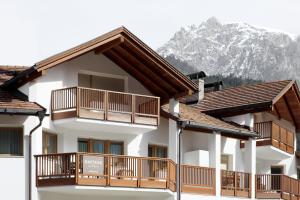 a building with wooden balconies and a mountain at DACIASA Apartment in San Vigilio Di Marebbe