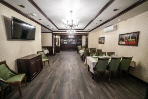 a dining room with tables and chairs and a flat screen tv at Boutique Hotel Russkaya Okhota in Samara