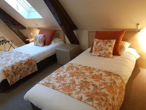 a bedroom with two beds and a window at Hotel Henri IV in Coutras