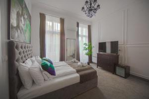 ein Schlafzimmer mit einem großen Bett und einem TV in der Unterkunft Kings Palace in Belgrad