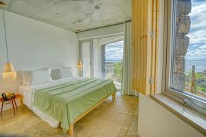 a bedroom with a bed and a large window at Socalco Nature Calheta in Calheta