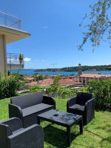 eine Terrasse mit 2 Stühlen und einem Tisch mit Aussicht in der Unterkunft Villa Ai Colli in Salò