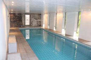 een zwembad in een gebouw met een tegelvloer bij Villa Gina App 6060 in Brissago