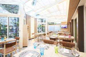 un ristorante con tavoli, sedie e finestre di Lungolago Rosso a Locarno