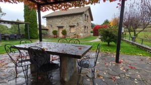 a table with chairs and a stone building at Casas Cleto - Laspuña in Laspuña