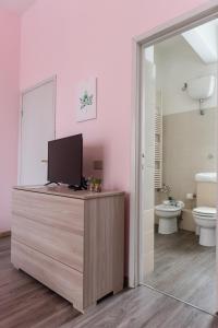 a bathroom with a tv on a counter with a toilet at Poggio del Sole Guest House in Arezzo