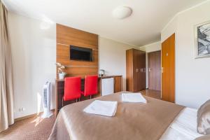 クリニツァ・モルスカにあるPokoje gościnne Nordのベッド1台と赤い椅子2脚が備わるホテルルームです。