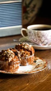 two muffins on a plate on a table with a cup of coffee at The King Alfred Pub in Winchester