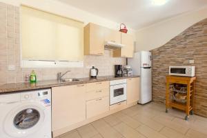 uma cozinha com uma máquina de lavar roupa e um frigorífico em Nissi 3 Pool Access Garden Apartment em Agia Napa