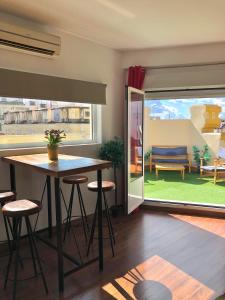 a living room with a table and chairs and a window at Constitución Terraza in Seville