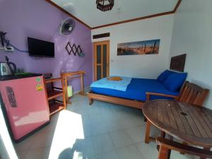 a small bedroom with a bed and a table and a tableablish at Runa Runa The Best Samed Island in Ko Samed