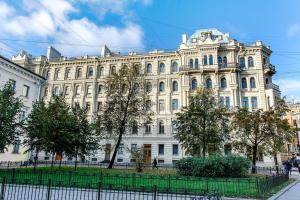 un gran edificio blanco con árboles delante de él en Epigraph Hotel, en San Petersburgo
