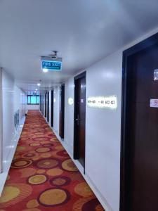 維沙卡帕特南的住宿－Fortune Inn Sree Kanya, Visakhapatnam - Member ITC's Hotel Group，建筑物的走廊,上面有读取消防出口的标志