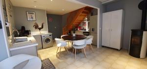 eine Küche und ein Esszimmer mit einem Tisch und Stühlen in der Unterkunft La Maison Clémenso in Cluny