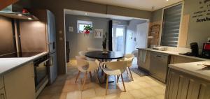 eine Küche mit einem Tisch und weißen Stühlen in der Unterkunft La Maison Clémenso in Cluny + 21 Fotos