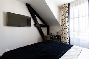a bedroom with a bed and a window at Jehan De Beauce - Les Collectionneurs in Chartres
