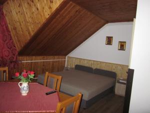 ein kleines Zimmer mit einem Bett und einem Tisch mit einem Tisch in der Unterkunft Tóth Vendégház in Parád