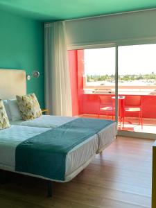 a bedroom with a bed and a table with chairs at Hotel Ritual Maspalomas - Adults Only in Playa del Ingles