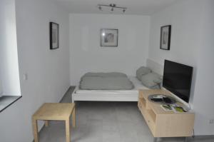 Habitación con cama, TV y mesa. en Appartment an der Wühle en Weilheim an der Teck