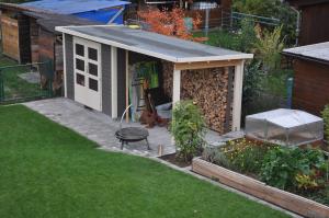 a small shed with a roof on a garden at Appartment an der Wühle in Weilheim an der Teck