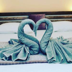 two towelsrendered to look like hearts on a bed at Casa Elena in Sibiu