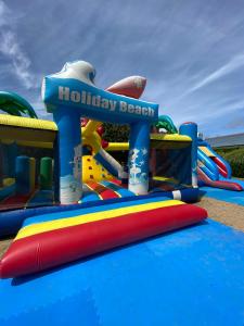 un parque infantil inflable con un letrero de playa sagrada. en Camping de Keranterec, en La Forêt-Fouesnant