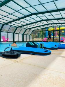 a swimming pool with blue surfboards on the floor at Camping de Keranterec in La Forêt-Fouesnant +46 photos