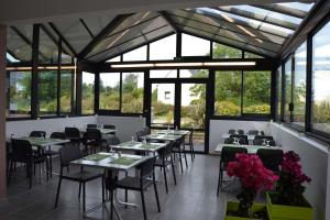 a dining room with tables and chairs and windows at Camping de Keranterec in La Forêt-Fouesnant
