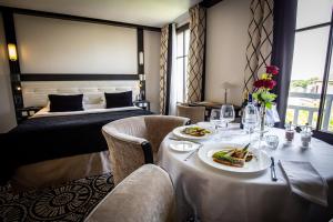 ein Hotelzimmer mit einem Tisch mit Essen und einem Bett in der Unterkunft Jehan De Beauce - Teritoria in Chartres