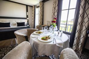 a dining room with a table and chairs and a bed at Jehan De Beauce - Teritoria in Chartres