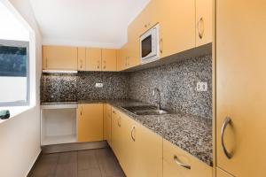 a kitchen with yellow cabinets and a sink at Vista Tarter Apartments in El Tarter