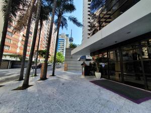 聖保羅的住宿－Lindo Studio com Jacuzzi e sacada a 50m Av Paulista，建筑物旁人行道上有人用雨伞