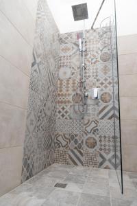 a bathroom with a shower with a mosaic wall at Country Boutique B&B Il Paradiso in Valmadonna