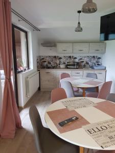 a kitchen with two tables and chairs in a room at Casa Alesia Bucovina in Gura Humorului