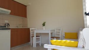 a kitchen with a table and a yellow chair in a kitchen at Mear Holiday Homes - Cretan Summer Getaways in Kountoura Selino