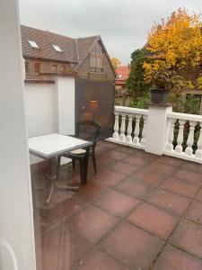 eine Terrasse mit einem Tisch und einer Bank auf einem Balkon in der Unterkunft Berliner Hof in Dallgow