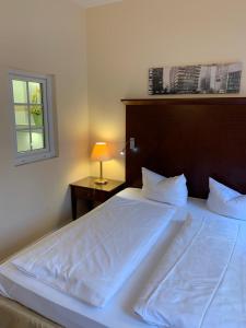 DallgowにあるBerliner Hofのベッドルーム1室(白いシーツが敷かれた大型ベッド1台、窓付)