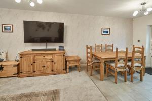 a dining room with a table and a television on a wall at Host & Stay - No 5 Hoggarths Yard in Whitby +13 photos